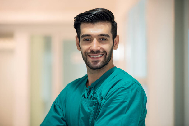Arckép jóképű orvos sebész áll a kórházi folyosón, egészségügyi és orvosi - Fotó, kép