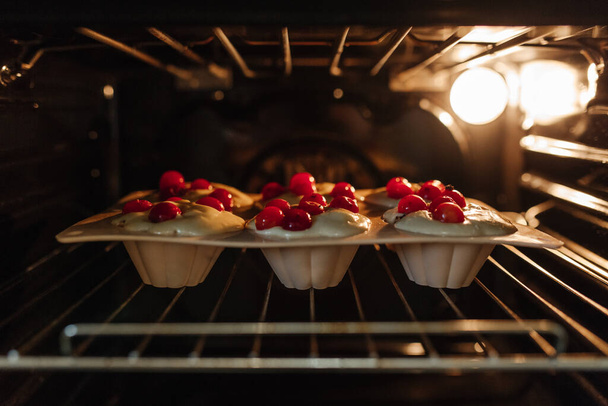 Kekleri fırında pişirme süreci. Kirazlı kek pişirmek için hamur.. - Fotoğraf, Görsel