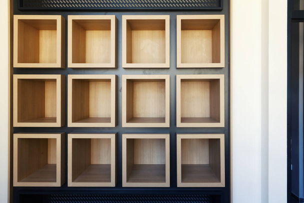 empty wooden shelves in the shape of cubes on the wall - Фото, зображення
