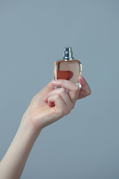 Perfume bottle in beautiful woman hands - 写真・画像