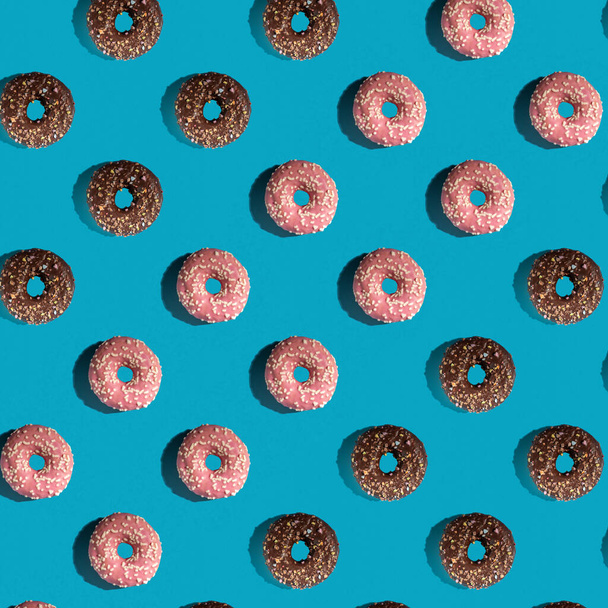 A pattern of delicious doughnuts on a blue background. Top view. Flat layer. Summer concept. - Photo, Image