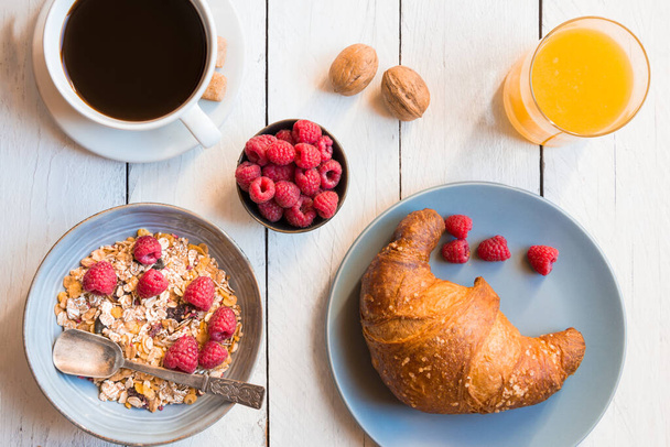 snídaně s croissanty, kávou a šálkem čaje na dřevěném stole - Fotografie, Obrázek