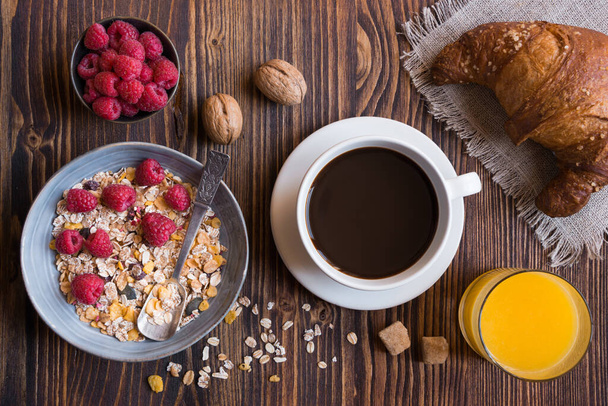 desayuno con croissants, café y bayas sobre mesa de madera - Foto, imagen