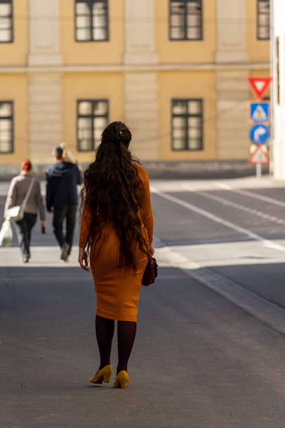 女性は通りを歩いている。本物の人々. - 写真・画像