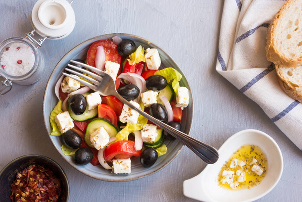 Griekse salade met feta kaas, tomaten, mozzarella, ui en basilicum - Foto, afbeelding