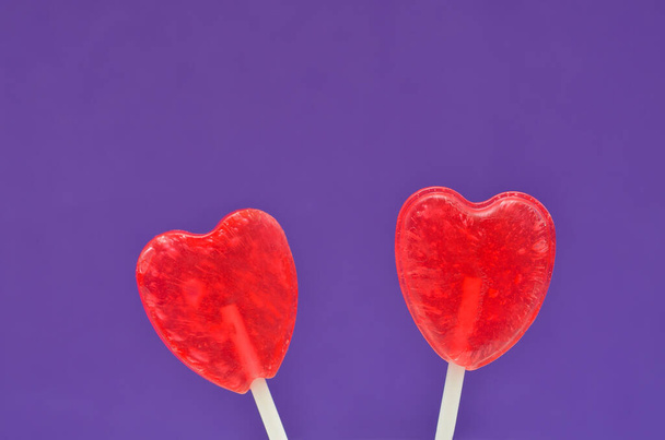 two heart-shaped lollipops on a lilac background - 写真・画像
