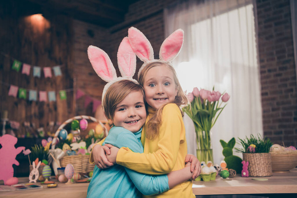Portrait of two idyllic adorable kids cuddle toothy smile look camera wear rabbit ears headband house indoors - Φωτογραφία, εικόνα