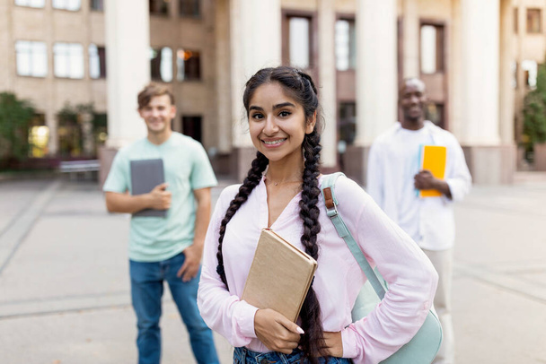 Future professionals. Portrait of multiracial university students posing near university building, focus on girl - Fotó, kép