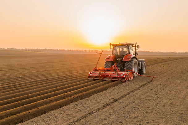Traktor fährt über Feldbeete zur Aussaat von Saatgut - Foto, Bild