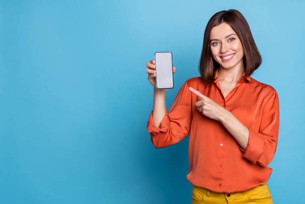 Portrait of attractive cheerful girl showing device gadget copy space ad offer isolated over bright blue color background - Fotografie, Obrázek