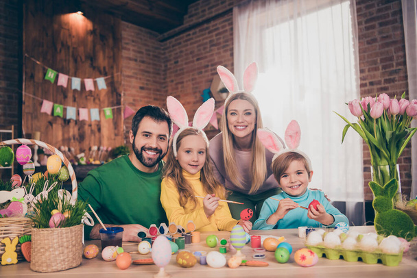 Photo of positive cheerful four people enjoy paint eggs prepare easter basket house indoors - Foto, Imagen