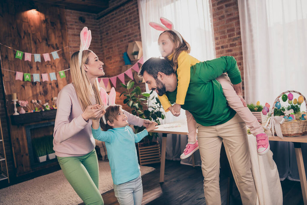 Фото гарного настрою смішні сім'ї розважаються разом батько тримає свинарник свою дочку, граючи з дітьми святкуючи великоднє свято
 - Фото, зображення