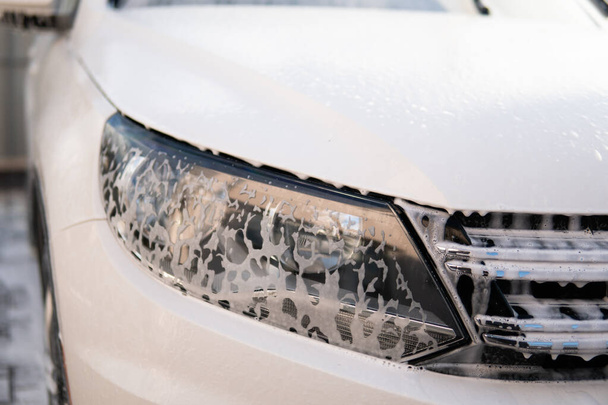 Cleaning Car Using Washing with soap. High Pressure Water. Close up. Manual car wash outside. Manual car wash with white soap, foam on the body. - Foto, immagini