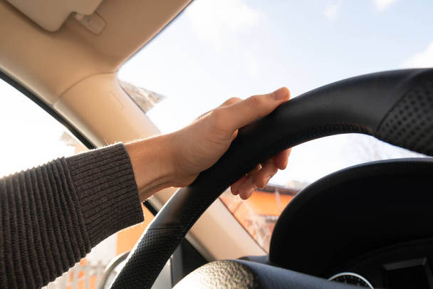 Man's hands of a driver on steering wheel of a minivan car on asphalt road - Photo, Image