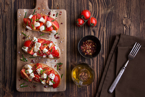 bruschetta con tomates, queso feta, tomate, albahaca y aceite de oliva. - Foto, Imagen