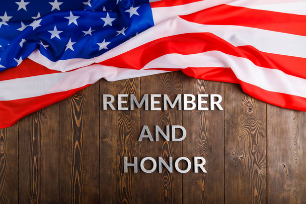 words remember and honor laid with silver metal letters on wooden background with USA flag above - Photo, image