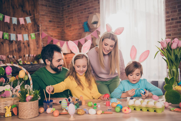 Portrait of beautiful handsome cheerful adorable family preparing party festal occasion draw eggs indoors - 写真・画像