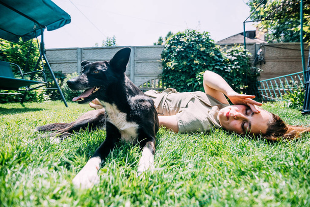 молода дівчина влітку грає на газоні з собакою, вона подряпає його, поки вона ліцензує і насолоджується. Пропозиції422
. - Фото, зображення