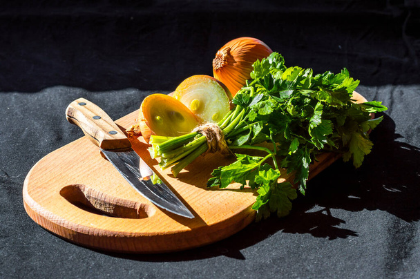 egetables, πράσινο μαϊντανό, κρεμμύδι, σε μια ξύλινη επιφάνεια κοπής - Φωτογραφία, εικόνα