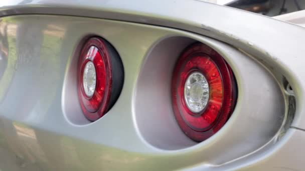 Nagy, piros, kerek hátsó lámpák egy versenyautó modern sport autó. - Felvétel, videó