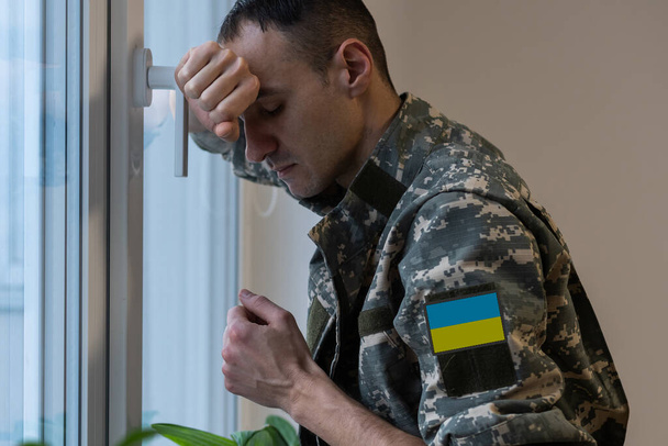 ウクライナの男戦士は軍のピクセルで服を着て、ウクライナの黄色の旗を統一 - 写真・画像
