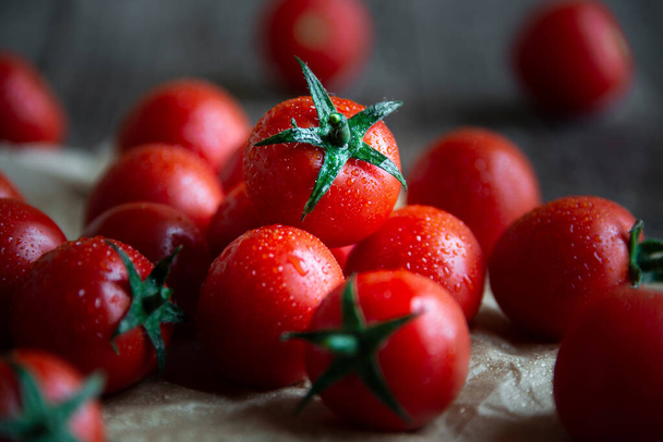 Fresh ripe organic cherry tomatoes on dark wooden background - Fotografie, Obrázek