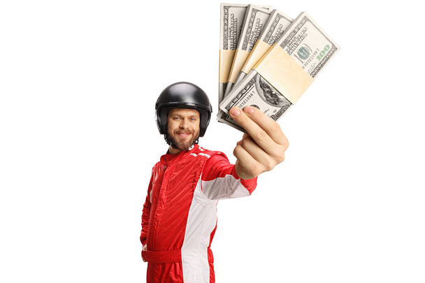 Racer holding stacks of money and smiling isolated on white background - Zdjęcie, obraz