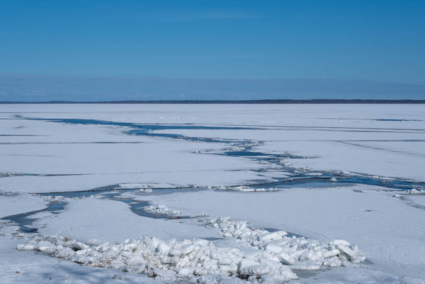 paisaje de primavera de la orilla del lago, cubitos de hielo blanco, cielo azul, lago Burtnieki, Letonia. - Foto, Imagen