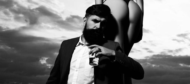 Rich man drink. Bearded businessman in elegant suit with glass of whiskey. Young couple in love outdoor. - Fotoğraf, Görsel