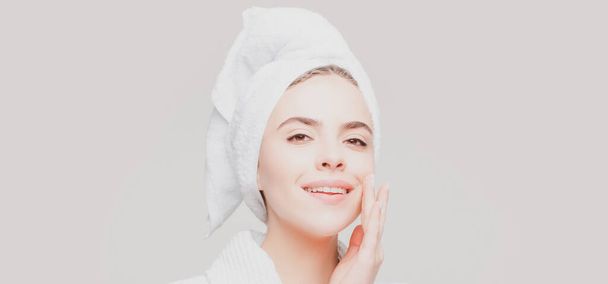 Portrait of beautiful woman applying cream to face for skin care. Cropped portrait isolated with copy space in a panorama banner. - Foto, Imagen