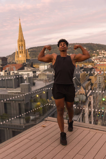 Arab young man doing sports in the city, showing off the great muscle of his arm - Fotoğraf, Görsel