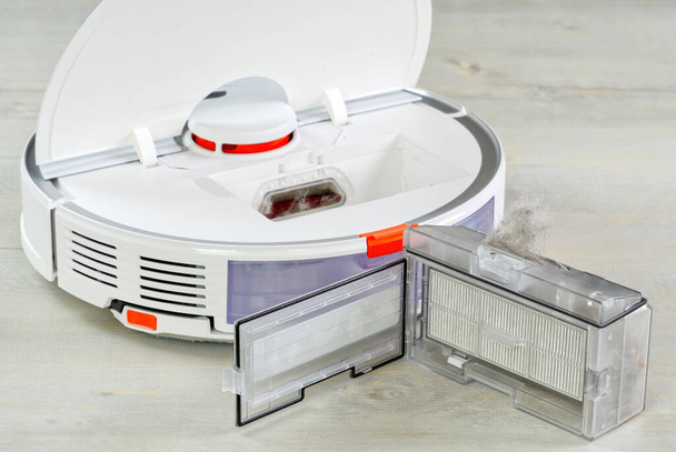 robot vacuum cleaner water tank removed and the filter lid is opened to clean. Smart cleaning and washing technology. advanced robot. - Photo, Image