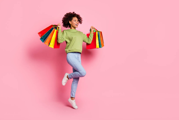 Full size profile side photo of young excited lady have fun jump look empty space shop store isolated over pink color background - Foto, afbeelding