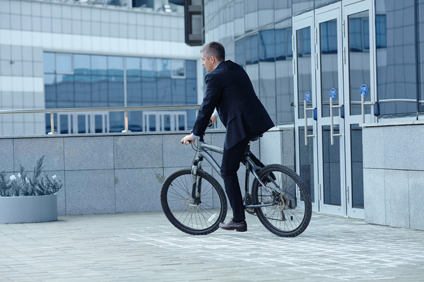 Businessman  riding  bicycle - Фото, зображення