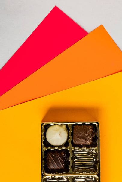 Kolorowe tło z częściowo widocznym pudełkiem czekoladek w dolnej części obrazu - Zdjęcie, obraz