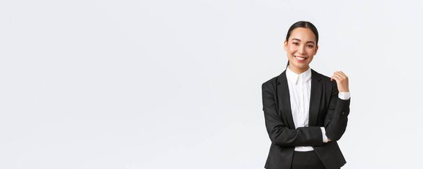 Стильна вродлива жінка-брокер продає будинки клієнтам. Азійська бізнесменка в костюмі посміхається щаслива і виглядає впевнено. Успішний керівник під час роботи, біле походження - Фото, зображення