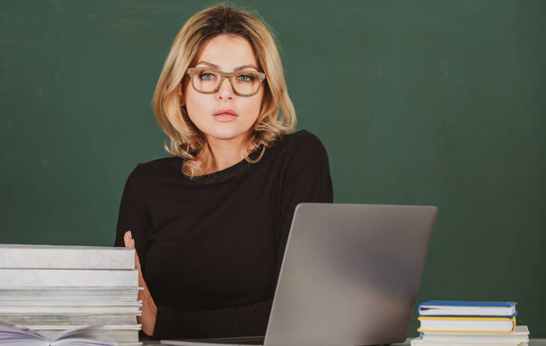 Closeup portrait of young sexy female teacher teaching line of high school students with computer laptop in classroom on blackboard. - Φωτογραφία, εικόνα