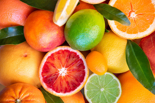 Varias frutas cítricas frescas con hojas, naranjas y pomelos - Foto, Imagen