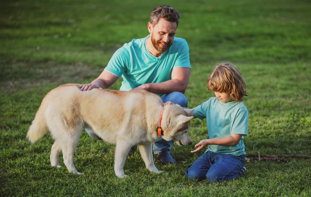 Smiling Father and Son with Pet. Happy Family with Loyal Pedigree Dog have Fun at the Backyard. - Photo, Image