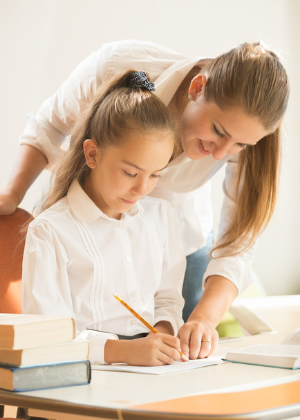 mother helping daughter with preparing to exam - Foto, imagen