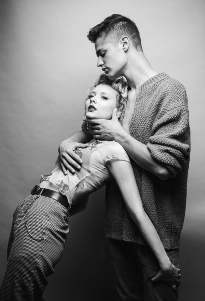 Affectionate couple while a photo session. Relax. Tender picture of young couple. Fashion studio photo of beautiful couple. Valentines day. Sensuality. Isolated on grey. - Foto, afbeelding