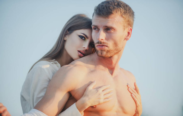Portrait of lovely couple in love. Young sensual girlfriend glad to passionate kiss from her boyfriend. Handsome young man embraces his woman and kisses. - 写真・画像