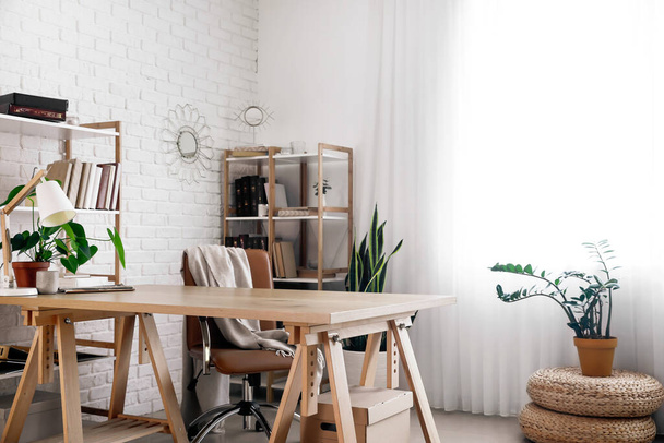 Belső tér világos iroda modern munkahely, fa könyvszekrények és szobanövények - Fotó, kép