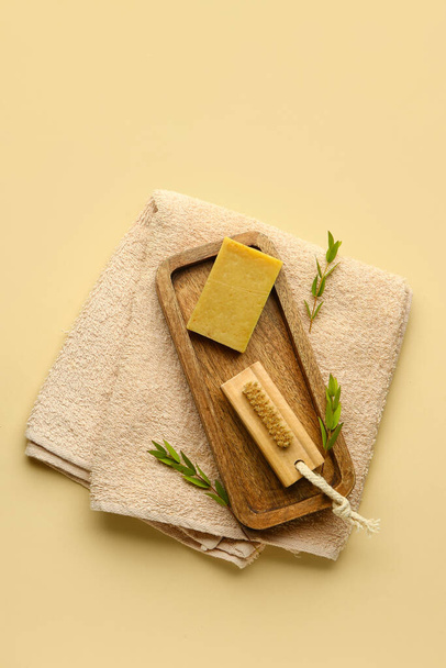 Wooden board with massage brush, soap and clean towel on color background - Foto, afbeelding