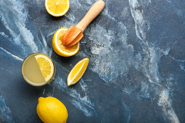 Композиція з стиглими лимонами, соковижималкою та склянкою соку на кольоровому фоні
 - Фото, зображення