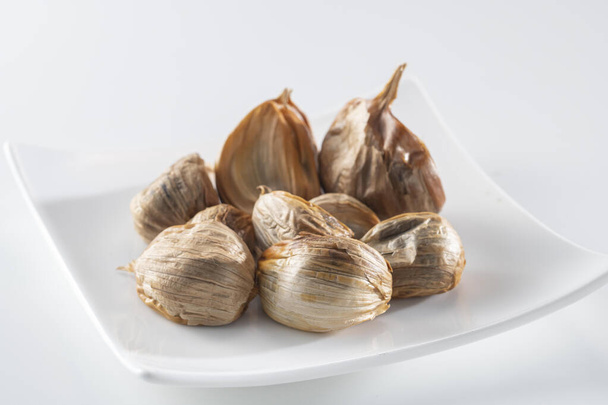 The black garlic is finished by cooking fresh and delicious garlic. - Photo, Image