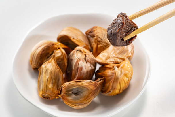 The black garlic is finished by cooking fresh and delicious garlic. - Photo, Image