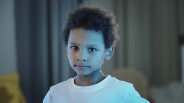 Kleiner schüchterner schwarzer Junge schaut in die Kamera - Filmmaterial, Video