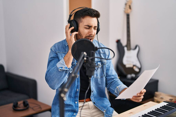 Young hispanic man singing song at music studio - Fotoğraf, Görsel
