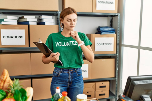 Young brunette woman wearing volunteer t shirt at donations stand feeling unwell and coughing as symptom for cold or bronchitis. health care concept.  - Photo, Image